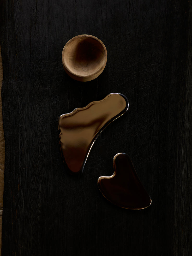 gua sha skincare tools on wooden board