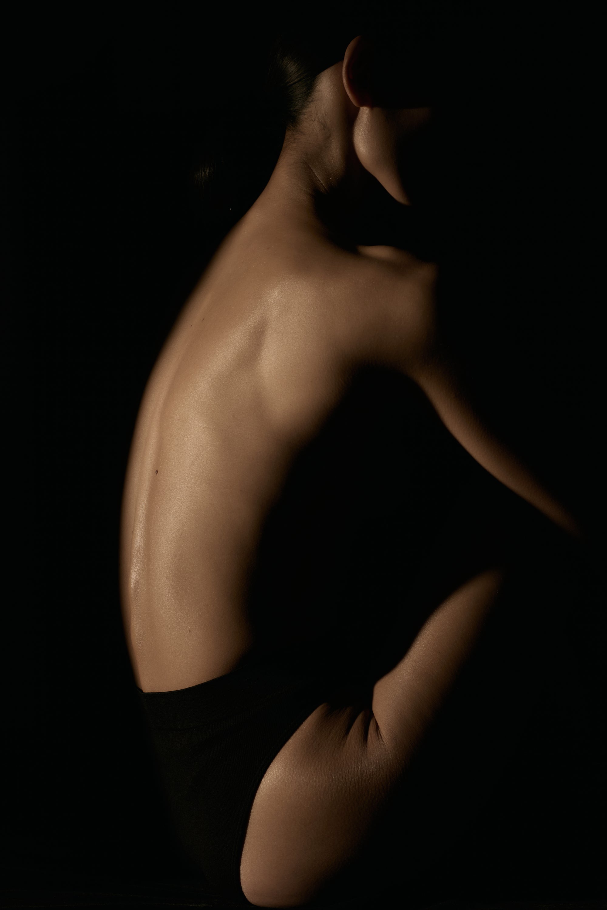 woman in a sitting position with a dark background