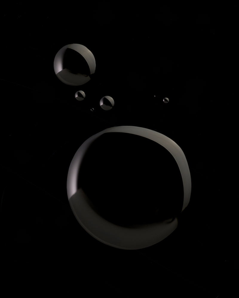 Black oil droplets on a black background