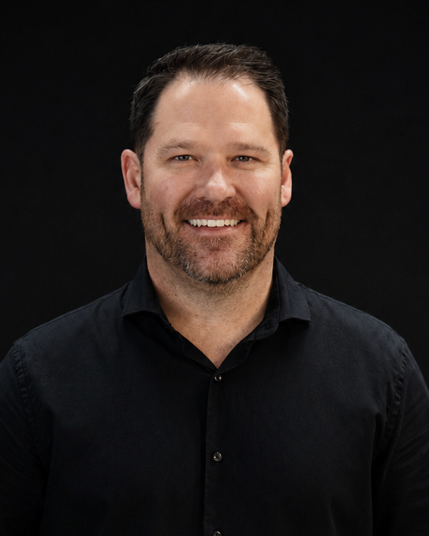Man wearing a black shirt against a black background